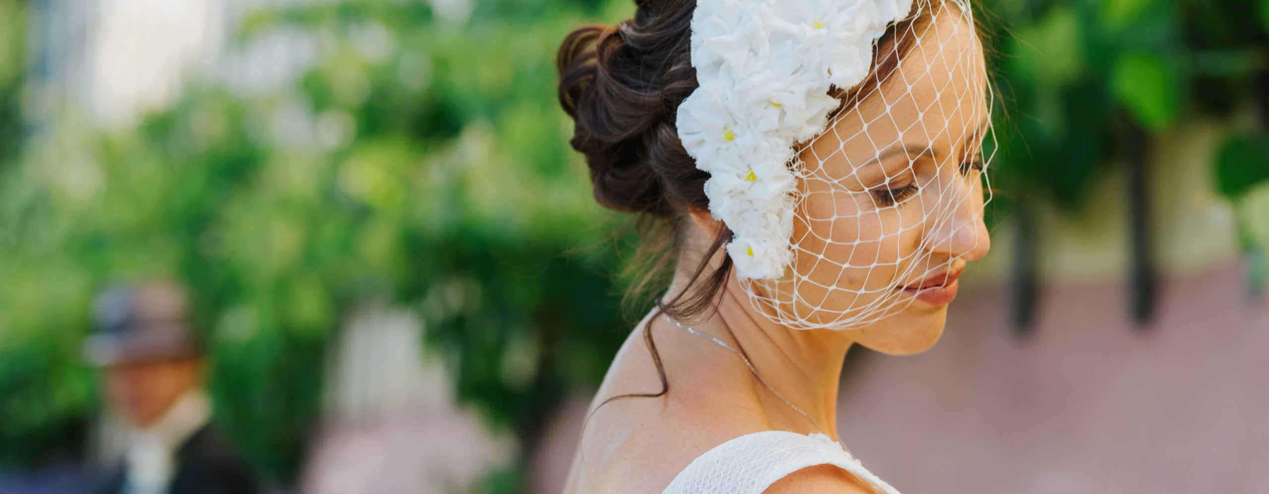 Braut mit Fascinator mit Vintageschleier