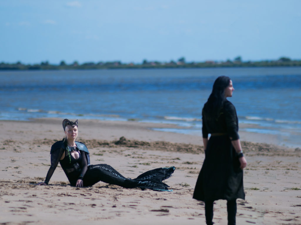 Meerjunfrau Miruna liegt am Strand und blickt den Seher Wilk an