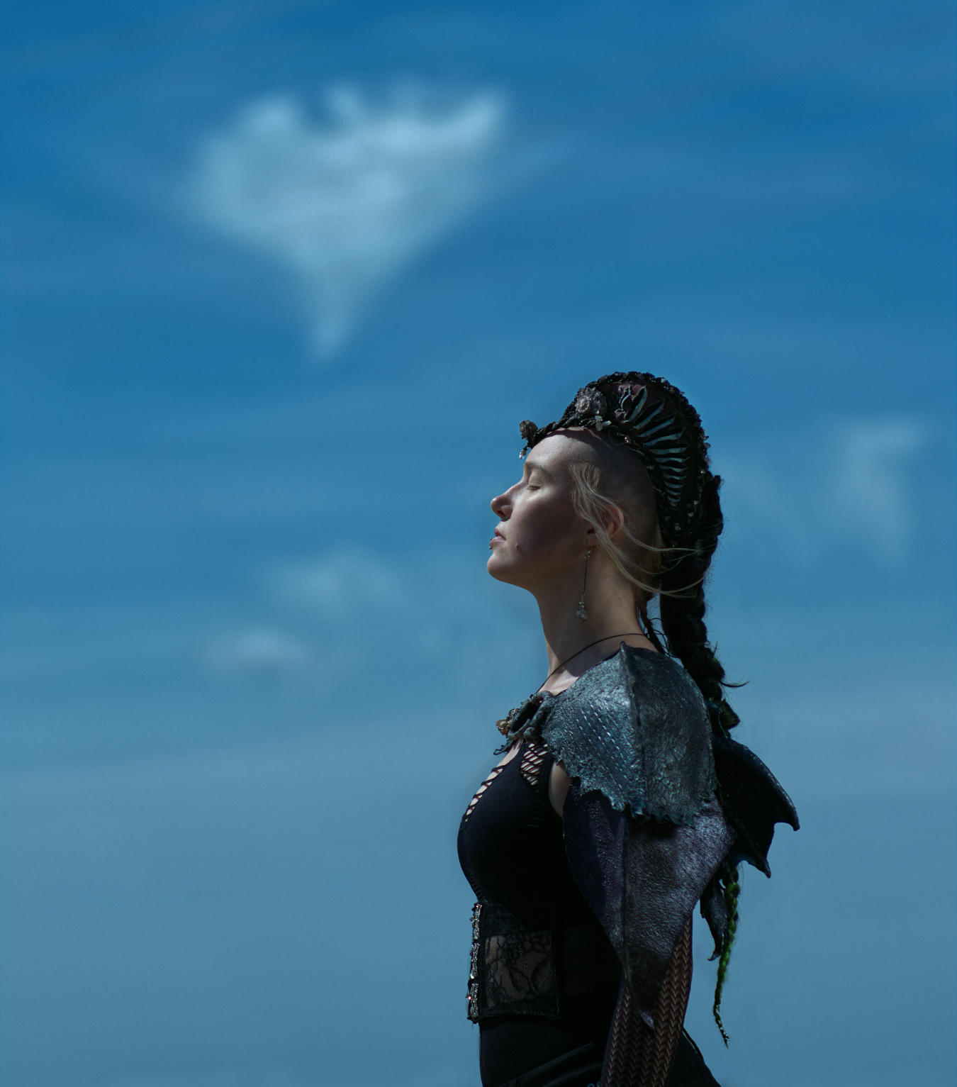 Meerjungfrau Miruna steht vor dem blauen Himmel mit einer Herzchenwolke