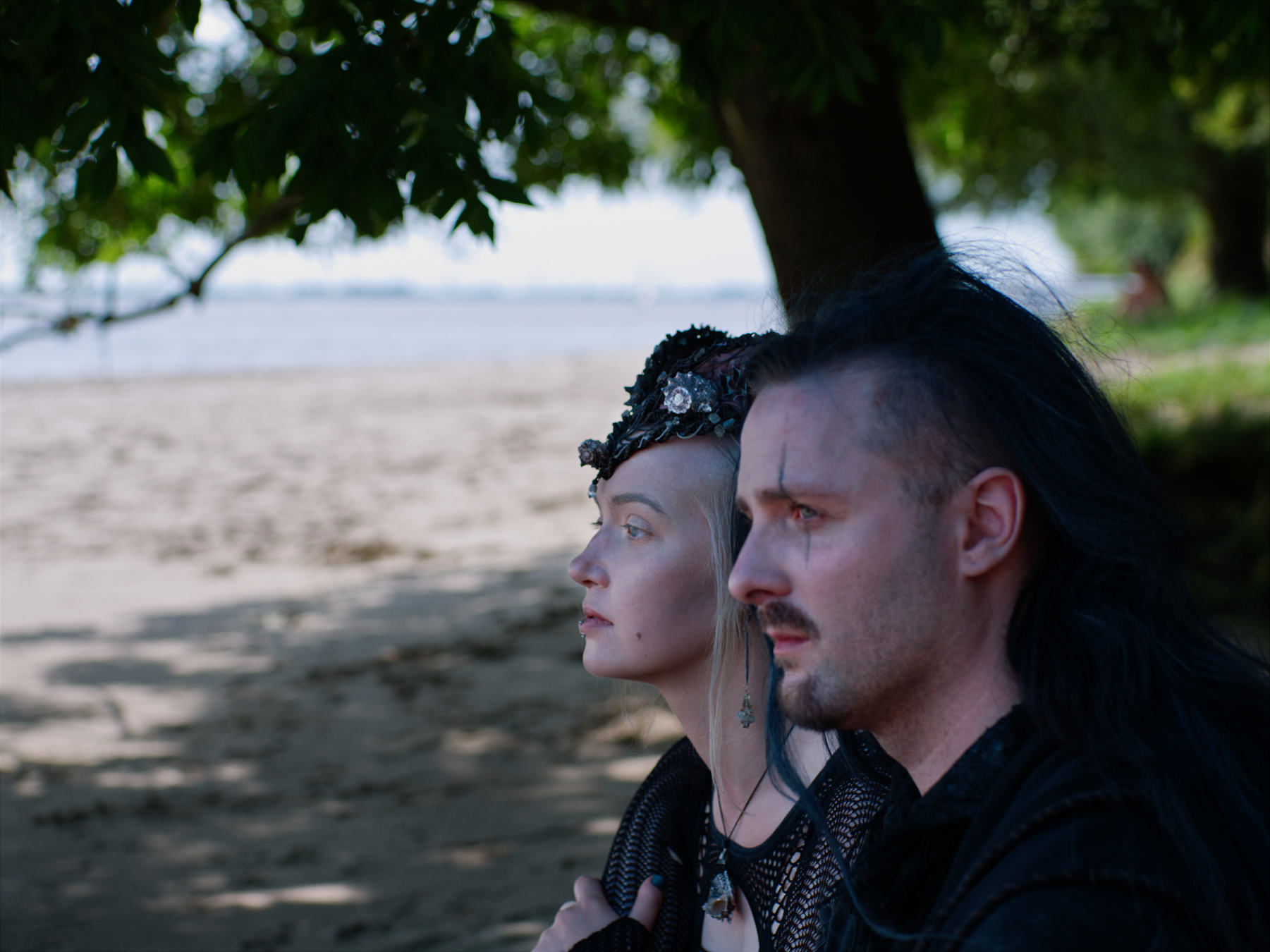 Meerjungfrau Miruna und Seher Wilk sitzen im Schatten eines Baumes am Strand